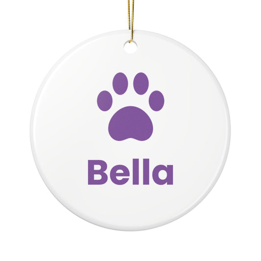 Round white ceramic dog ornament with a purple paw print and the name Bella